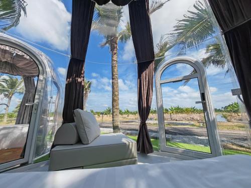 Cette chambre comprend un lit et offre une vue sur les palmiers. dans l'établissement The Coco Journey - Eco Dome, à Malacca