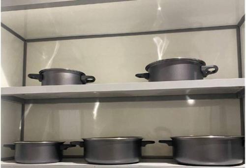 three pots on a shelf in a kitchen at Elegant apartment in Jeddah