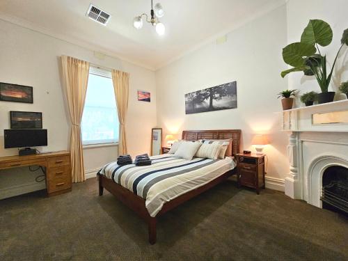 1 dormitorio con 1 cama con chimenea y TV en Unley Retreat, en Unley