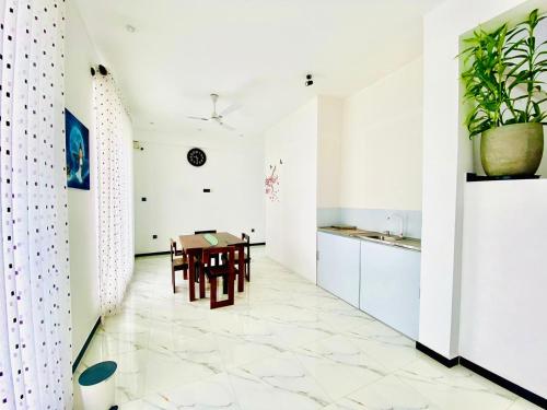 a kitchen and dining room with white cabinets and a table at Airport Faith Hotel in Katunayake
