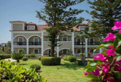 a large white building with a yard at Sofia - Yiota Studios & Apartments in Tsilivi