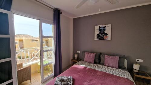 a bedroom with a bed and a balcony at Residencial Benimar Licencia Vv in Adeje