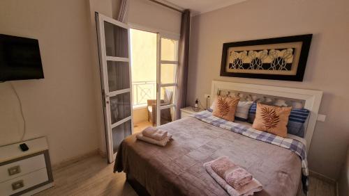 a bedroom with a large bed and a window at Residencial Benimar Licencia Vv in Adeje