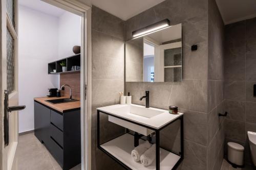 ein Bad mit einem Waschbecken und einem Spiegel in der Unterkunft Ranny House in Athen