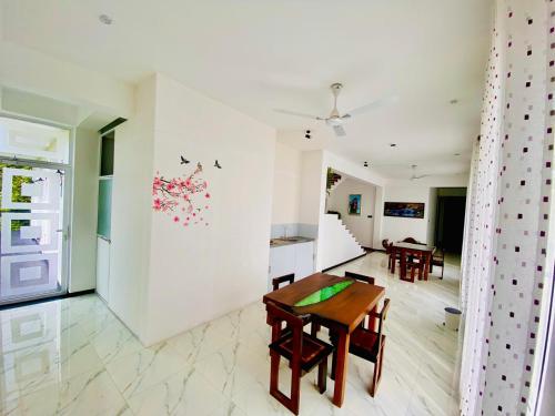 a living room with a table and a dining room at Airport Faith Hotel in Katunayake