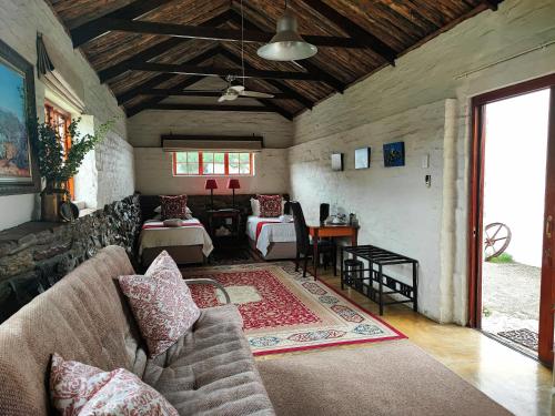 een woonkamer met een bank en een tafel bij Ganora Guest Farm, Camping and Excursions in Nieu-Bethesda