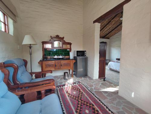 a living room with a couch and a table at Ganora Guest Farm, Camping and Excursions in Nieu-Bethesda