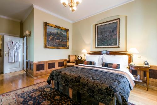 a bedroom with a large bed and two paintings on the wall at Golden Well in Prague
