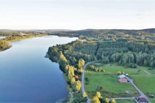 una vista aerea di un fiume alberato e di una casa di Stuga Fyra Säsonger - Fishing - Skiing - Hottub a Filipstad