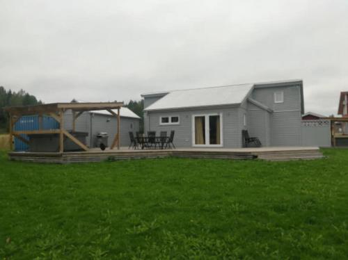 a small house with a deck and a patio at Stuga Fyra Säsonger - Fishing - Skiing - Hottub in Filipstad