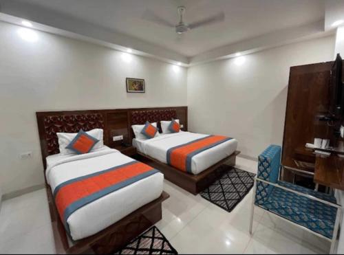 a hotel room with two beds and a television at OYO Townhouse 843 Stay Inn in New Delhi