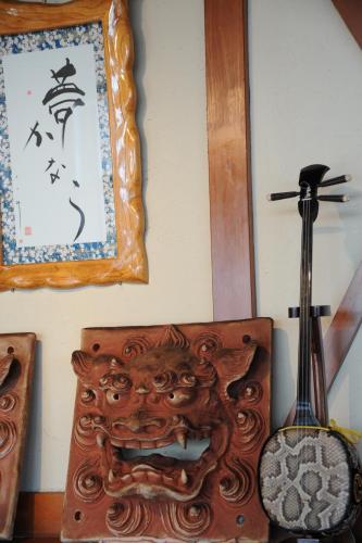 a clock on a wall with a guitar on a table at Kanucha Bay Hotel & Villas in Nago