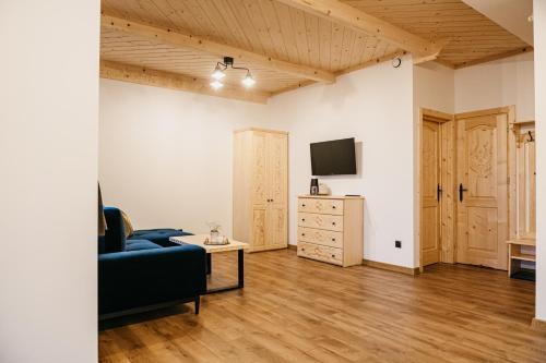a living room with a couch and a tv at Apartamenty Górajski Spa in Kościelisko