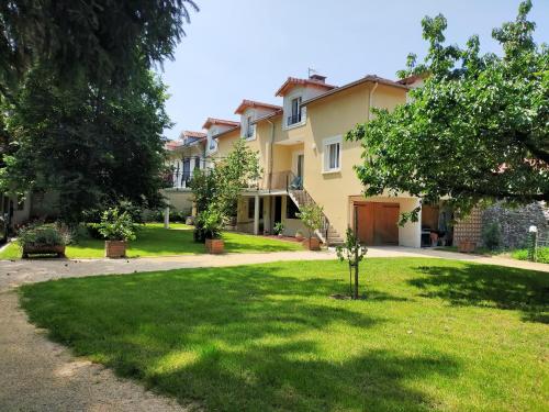 a large yellow house with a yard with grass at Le Jardin du Dolaizon in Le Puy en Velay