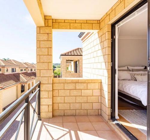 a bedroom on the balcony of a house at The Scarborough Beach House - Walk to the beach! in Perth