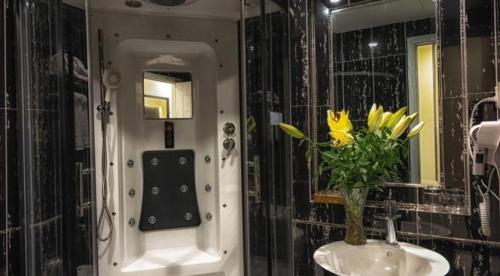 baño con lavabo y jarrón de flores amarillas en Tuong Vi Hotel, en Hai Phong