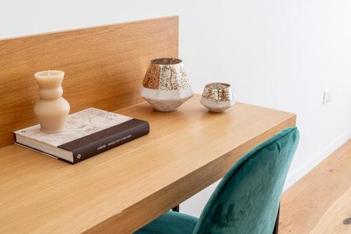 a wooden table with a book and vases on it at SoClà Boutique Hotel RTA in Taranto