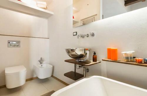 uma casa de banho branca com uma banheira e um WC em Bright and Peaceful Apartment in Historic Palazzo em Bolonha