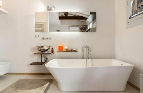 uma banheira branca numa casa de banho branca em Bright and Peaceful Apartment in Historic Palazzo em Bolonha