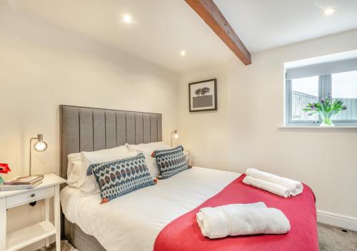 a bedroom with a large bed with a red blanket at Swallows Barn in Little Snoring