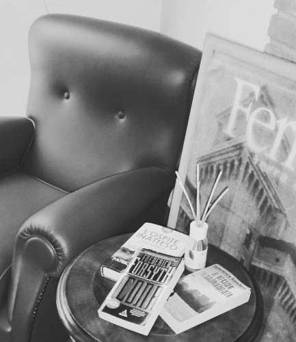 a coffee table with a book and a magazine on a chair at DIMORA AL SARACENO in Ferrara