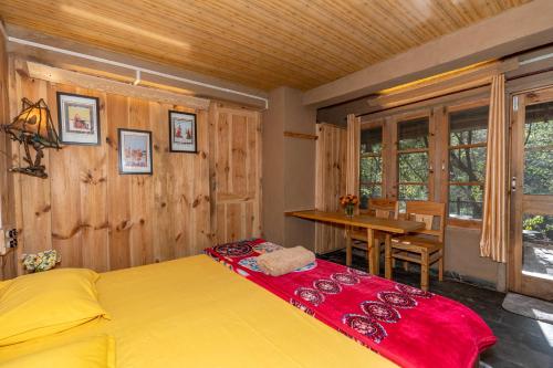 a bedroom with a bed and a table and a dining room at NotOnMap - H2O House in Chamba