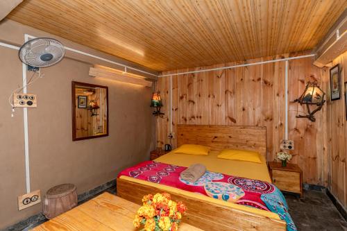 a bedroom with a bed with a wooden ceiling at NotOnMap - H2O House in Chamba