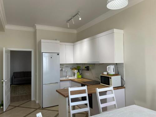 a kitchen with white cabinets and white appliances at ЖК Три короны in Aktau