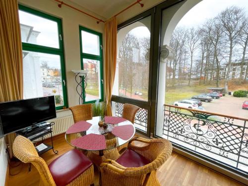 ヘリングスドルフにあるVilla Perkunosのテーブルと椅子、バルコニーが備わる客室です。