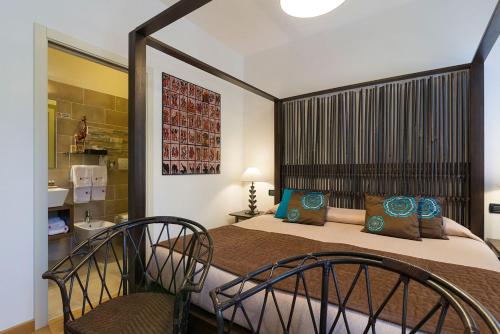 a bedroom with a bed with two chairs and a sink at Hotel Relais San Nicolò in Treviso