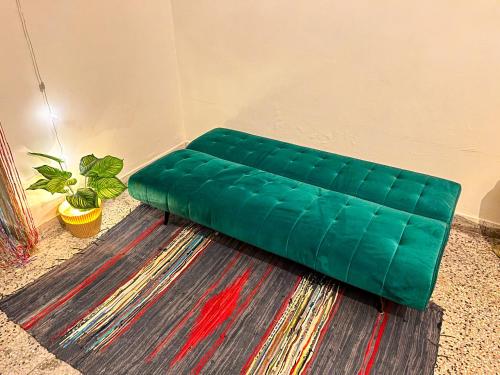 eine grüne Couch auf dem Boden in einem Zimmer in der Unterkunft Bliss Studio’s - Entire 1 BHK Apartment in Nagpur