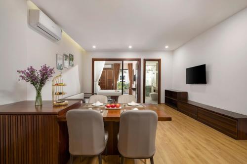 a dining room and living room with a table and chairs at Dana Boutique Hotel & Apartment in Da Nang