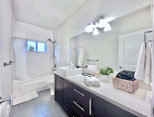a bathroom with a sink and a toilet and a tub at Si & Daniel Home Near YVR Airport & Skytrain Separate Entry Free Parking in Richmond