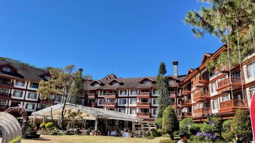a large apartment building with a tent in front of it at Mountain view room at Forest Lodge Hotel, Camp John Hay-Private unit 549 in Baguio