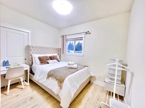 een slaapkamer met een bed, een bureau en een raam bij Si & Daniel Home Near YVR Airport & Skytrain Separate Entry Free Parking in Richmond