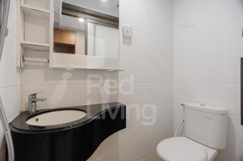 a white bathroom with a sink and a toilet at RedLiving Apartemen Sky House BSD - Lovely Space Tower Leonie in Cilenggang
