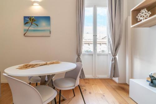 einen weißen Tisch und Stühle in einem Zimmer mit Fenster in der Unterkunft SoClà Boutique Hotel in Taranto