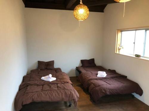 Dos camas en un dormitorio con toallas. en base sanablend - Vacation STAY 37411v, en Kyotango