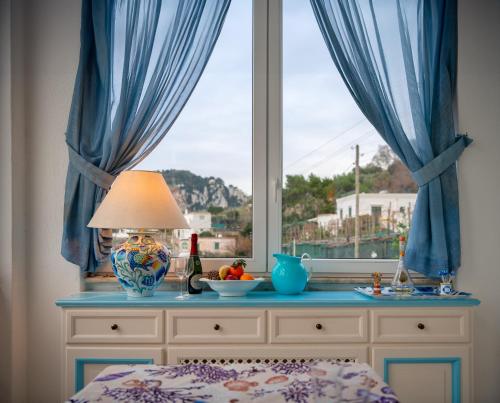 una camera da letto con finestra e tavolo con lampada di Casa Franca appartamento vista mare a Capri