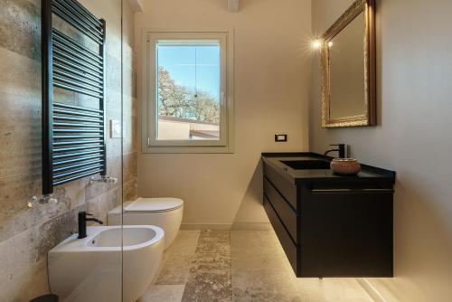 baño con lavabo y aseo y ventana en Baciucco's Suite, en Perugia