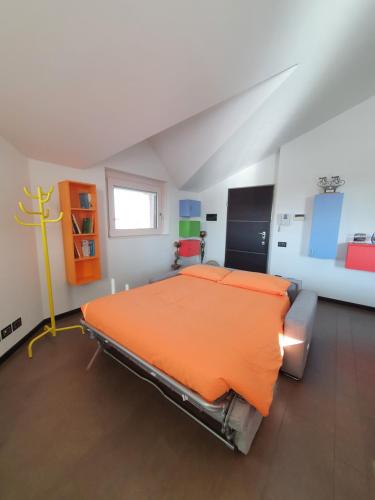 una camera da letto con letto arancione in mansarda di B&B Casa Sara a Cassano dʼAdda