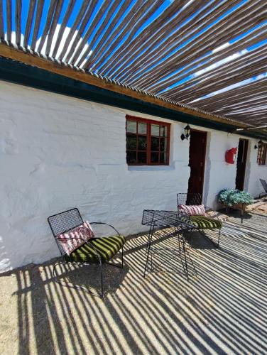two chairs and a table on a patio at Ganora Guest Farm, Camping and Excursions in Nieu-Bethesda