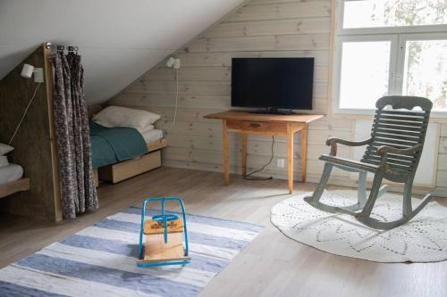 Habitación con cama, silla y escritorio. en Ihana järvenranta mökki. Cottage by the lake., en Kurjalanranta