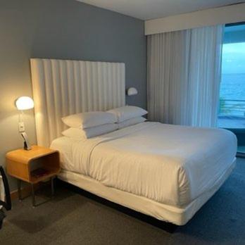 Un dormitorio con una gran cama blanca y una ventana en GreenWhood, en Caguas