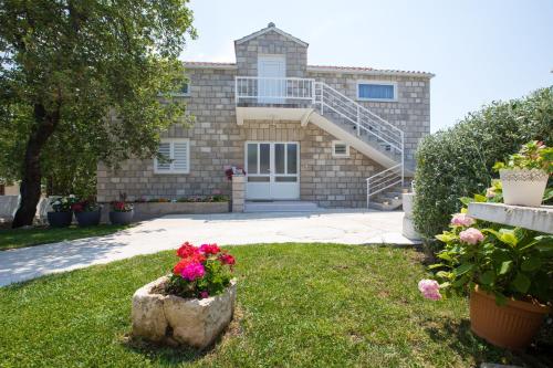 a house with flowers in the front yard at RELAXING HOME LUCE in Čilipi