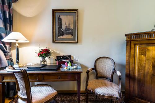 an office with a desk with two chairs and a lamp at Golden Well in Prague