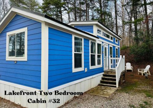 a blue tiny house with a porch and stairs at Long Cove Resort and Marina in Charlotte