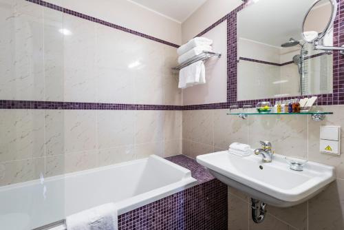 a bathroom with a sink and a bath tub at Golden Well in Prague