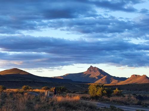 a view of the desert with mountains in the background at Ganora Guest Farm, Camping and Excursions in Nieu-Bethesda