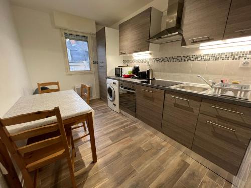 une cuisine avec une table, un évier et une cuisinière dans l'établissement Résidence RIVES DE LOIRE parking gratuit, à Blois